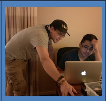 Two men look at computer screen