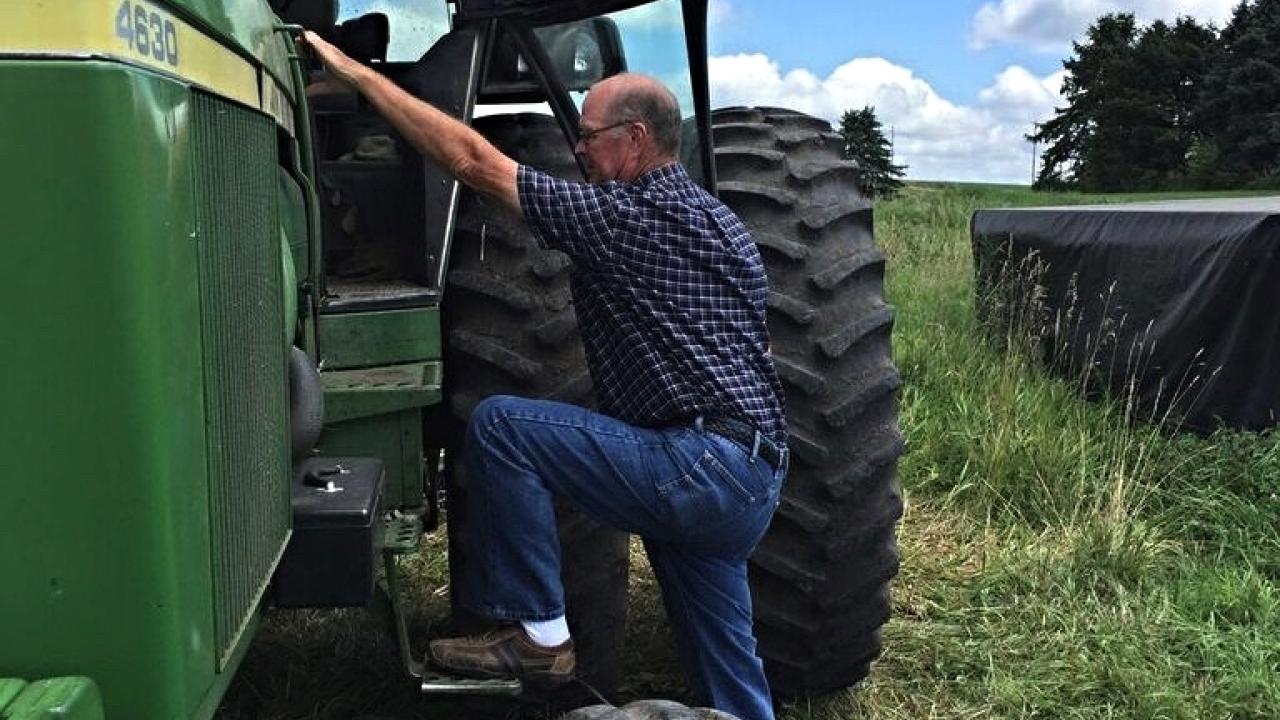 Farmer getting into tractor