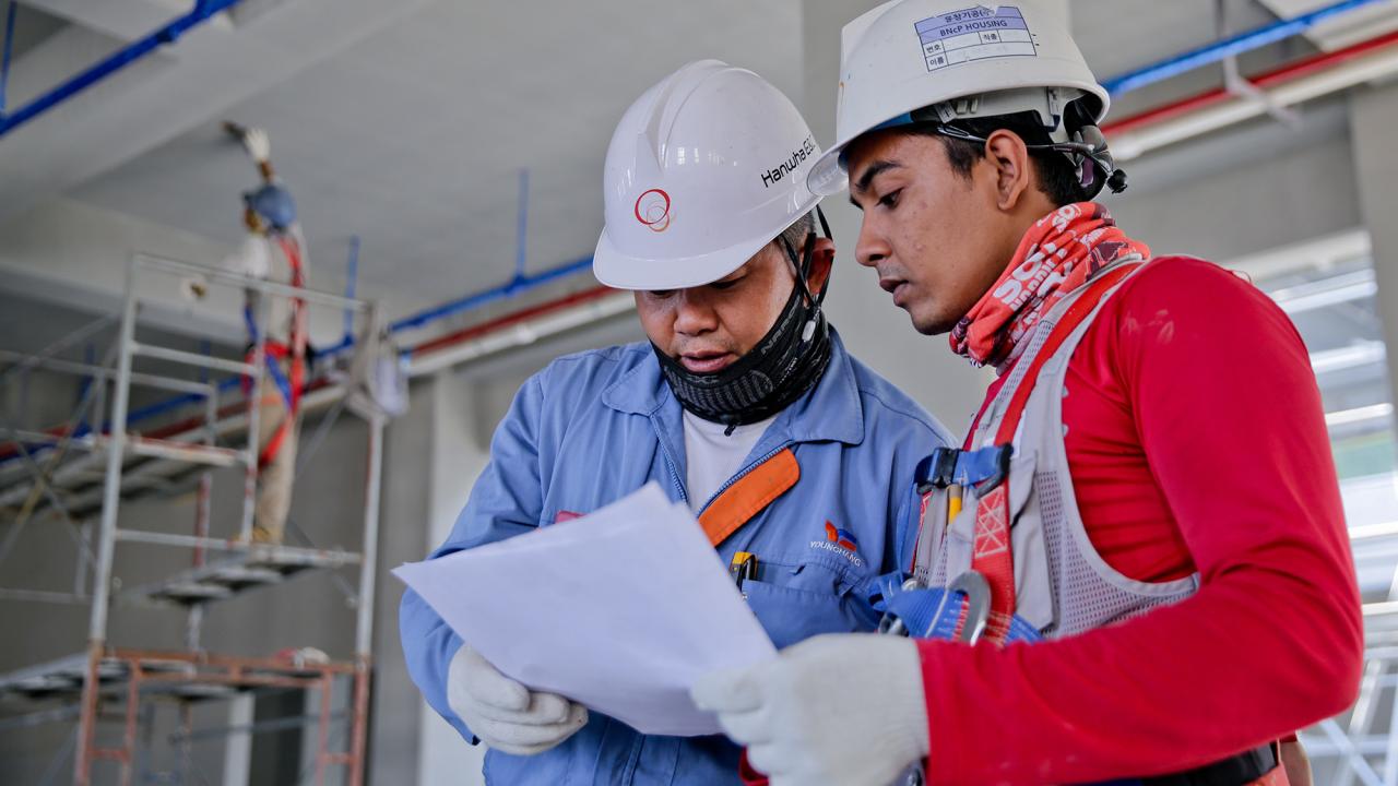 Two workers discuss plans