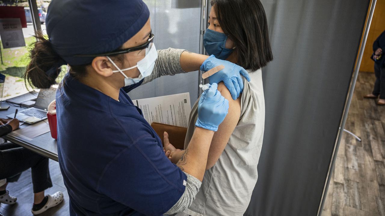 A woman receives a COVID-19 vaccine at a clinic