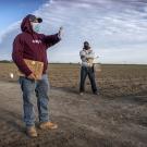 A supervisor trains farmworkers in the field